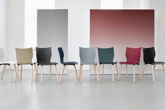Zeven stoelen in verschillende kleuren (beige, zwart, donkerblauw, lichtgrijs, groen, rood) met houten poten in minimalistisc