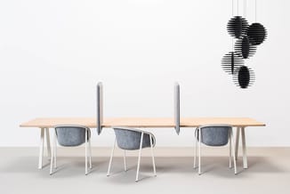 Houten vergadertafel met witte poten, drie grijze stoelen, grijze akoestische schermen en zwarte hangende akoestische element