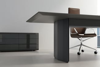 Modern werkstation met grijze tafel, donkergrijs kastje, bruinen draaibare bureaustoel en zwart laag dressoir in minimalistis