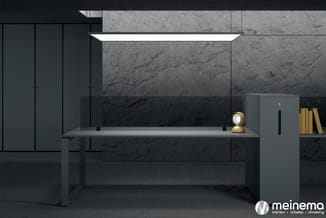 Moderne kantoorruimte met grijs bureau, zwarte kasten, marmeren wand, gouden bureaulamp en gele boekenboekenkast.