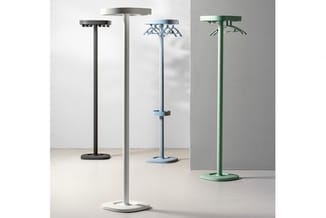 Vijf staande infraroodverwarmers in verschillende kleuren (zwart, grijs, blauw, groen) met platte voetplaten, opgesteld in ee