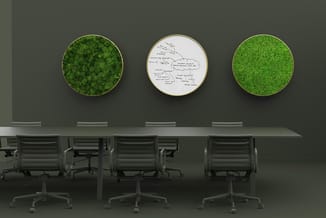 Conferentieruimte met lange tafel, grijze bureaustoelen en drie ronde wandpanelen met groene mos en één met handgeschreven no