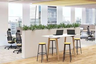 Modern kantoorinterieur met beige plantenbak als scheidingswand, witte bar met houten frame, gele barkrukken, zwarte bureaust