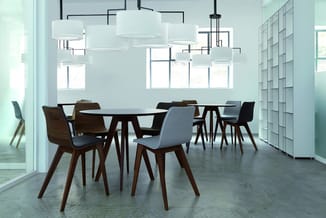 Moderne vergaderruimte met ronde zwarte tafel, houten stoelen met grijze zitting, hangende witte cilindervormige lampen en gr
