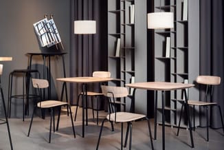Moderne kantoorruimte met twee houten tafels en lichte stoelen met zwart metalen frame, zwarte kastenwand, hangende cilinderv