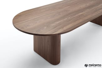 Ovale houten vergadertafel met donker walnoothout finish en massief voetonderstel, bovenaanzicht.