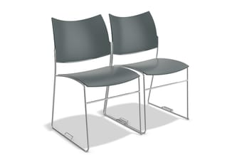 Twee grijze stapelstoelen met zilvergrijze metalen frame en gebogen rugleuning, naast elkaar geplaatst.