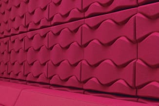 Roze akoestisch wandpaneel met golfpatroon en drie-dimensionale structuur voor geluidisolatie.