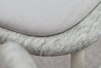Grijze bureaustoel met gestoffeerde zitting en rugleuning, detail van de ergonomische curve en textielafwerking.