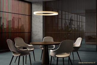 Moderne vergaderruimte met ronde zwarte tafel, vier grijze stoelen met armleuningen, ronde hanglamp, betonnen kolom en donker