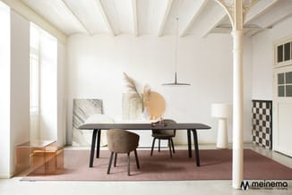 Moderne vergaderruimte met zwarte tafel, grijze stoelen, hangende zwarte lamp, wit plafond met balken en roze aardetinten tap