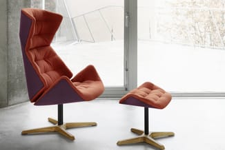 Rood/oranje relaxstoel met hoge rugsteun en bijpassende voetenbankje, zwarte zuil en houten stervoet, in minimalistisch inter