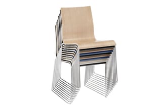 Gestapelde kantinestoelen met natuurlijk houten zitting en geboorde aluminium frames in zilver, verschillende kleuren zichtba