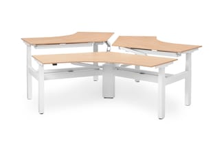 Elektrisch verstelbare werkplekken met beige houten tafelbladen en wit onderstel, in U-vorm opgesteld.