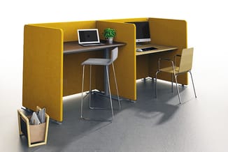 Twee gele akoestische werkboxen met bureaus, witte barkrukken, monitors, laptop en plant op grijze vloer.