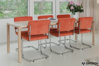 Houten vergadertafel met vijf oranje gestoffeerde kantoorstolen met chromen frame in moderne kantoorruimte met ramen.