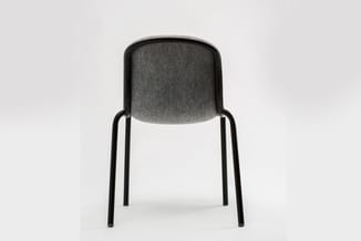 Grijze stoel met zwart metalen frame, afgeronde rugleuning, frontaal gefotografeerd tegen witte achtergrond.