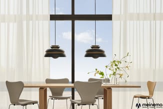 Moderne eetkamer met houten tafel, grijze stoelen, twee zwarte hangende lampen, witte verticale raamgordijnen en uitzicht op