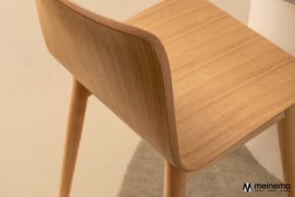 Houten stoel met gebogen rugleuning en zitting in natuurlijk houtkleur, getoond in onderaanzicht tegen beige achtergrond.