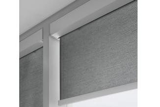 Grijs akoestisch wandpaneel met aluminium montageframe tegen plafond in kantoorinterieur.