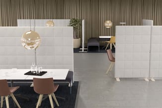 Modern kantoor met witte akoestische scheidingswanden, bruine stoelen, witte tafel, gouden hanglamp en grijs betonnen vloer.
