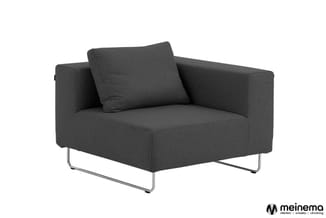 Donkergrijze fauteuil met armleuningen, rechthoekige zitting, vier stalen poten, decoratief kussen.