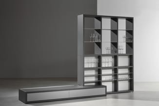 Moderne grijze kast en lowboard combinatie: regelmatige glazen vakken met glaswerk en zwarte metalen frame naast laag TV-meub
