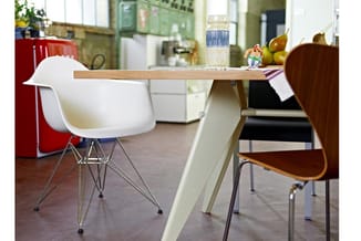 Moderne kantoorinrichting met houten tafel, witte stoel met metalen poten, bruine houten stoel, glas water, peren en rode kas