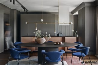 Moderne vergaderruimte met ronde zwarte tafel, blauwe stoelen, houten vloer, donkergrijs accent wall en gouden hanglamp boven