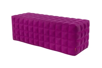 Paarse gestoffeerde pouf of bankje met gechequeerd kapitonnépatroon en gouden detail.