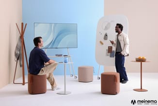Twee mannen in modern kantoor met bruine poefzitels, blauwe display, witte whiteboard met materiaalstalen en houten accessoir
