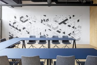 Vergaderruimte met blauwe vergadertafel, grijze bureaukstoelen en isometrische architectuurtekening op wand.