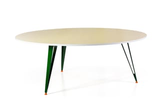 Ovale vergadertafel met lichte houten blad en vier schuine poten in groen en zwart met oranje accenten.