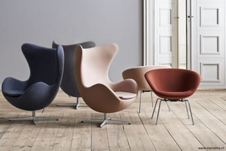 Vijf designstoelen in verschillende kleuren (donkerblauw, grijs, beige, taupe en terracotta) met organische vormen op houten