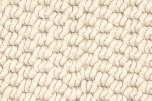 Close-up van crèmekleurig geweven stofpatroon met gestructureerde textuur voor meubelbekleding.