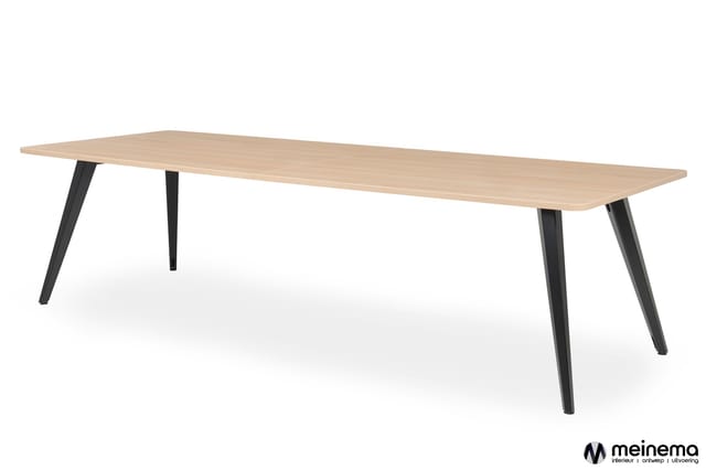 Rechthoekige vergadertafel met licht houten blad en zwarte schuine poten, perspectief van schuin boven.