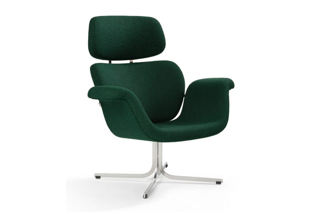 Groene fauteuil met hoge rugleuning en neckrest, gebogen armsteunen, op chromen draaivoetstuk met wieltjes.