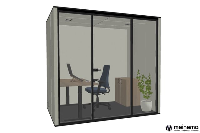 Glazen belcel met zwart frame, werkplek met bureau, bureaustoel, plant en kastje tegen grijze wand.