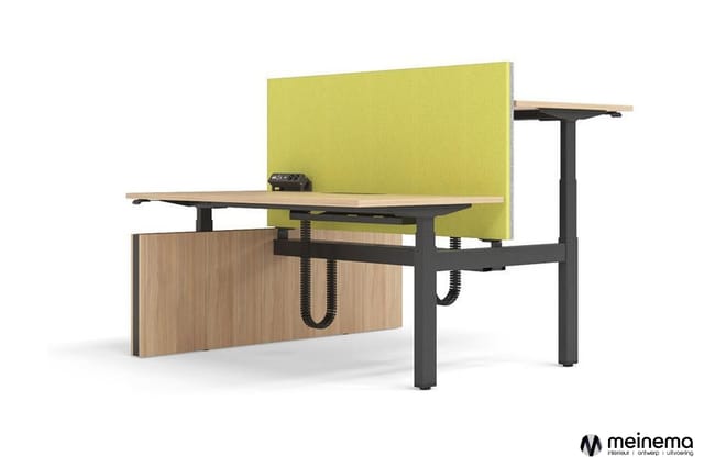 Elektrisch verstelbaar bureau met zwart metalen frame, houten blad en geel akoestisch scherm. Houten kastfront met geïntegree