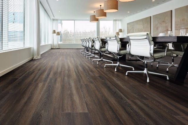 Moderne vergaderruimte met zwarte houten vloer, rij witte ergonomische bureaustoelen, zwarte vergadertafel, grote ramen en ha