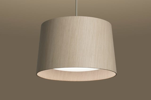 Hangende textiellampe in beige met cylindrische vorm, onderkant open, tegen neutrale achtergrond.