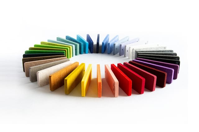 Kleurenkaart met verschillende stoffering- en materiaalmonsters in een cirkel, inclusief groene, blauwe, witte, gele, oranje,