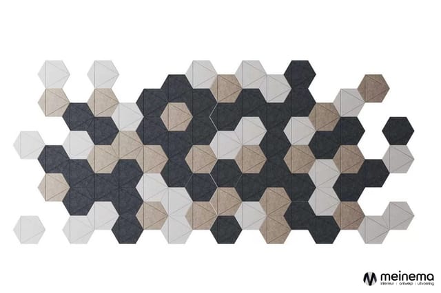 Hexagonale akoestische wandpanelen in grijs, zwart en beige, gerangschikt in abstract patroon op witte achtergrond.